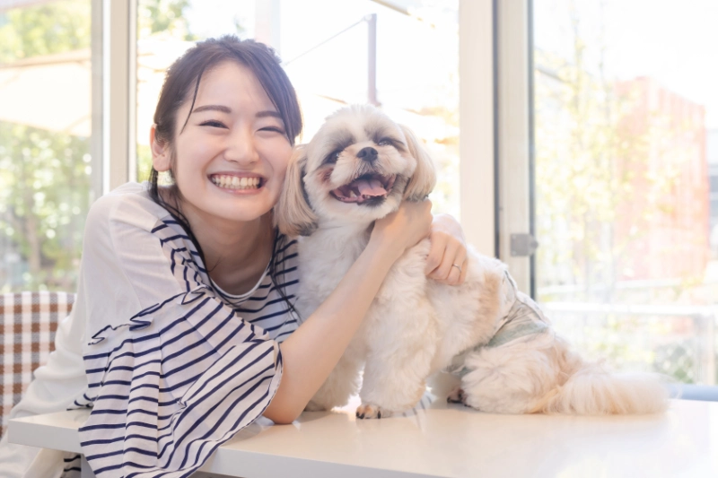 犬をなでる笑顔の女性